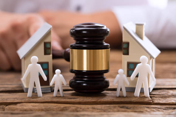 Close-up of mallet showing separation of family and house on wooden desk